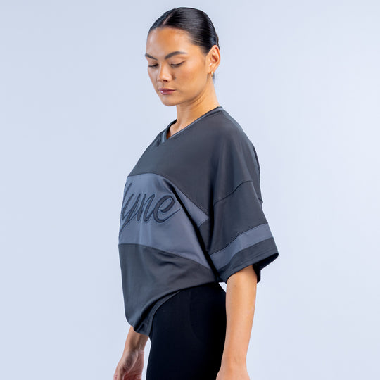 Dark short-sleeve top with large printed logo panel and graphic number detail