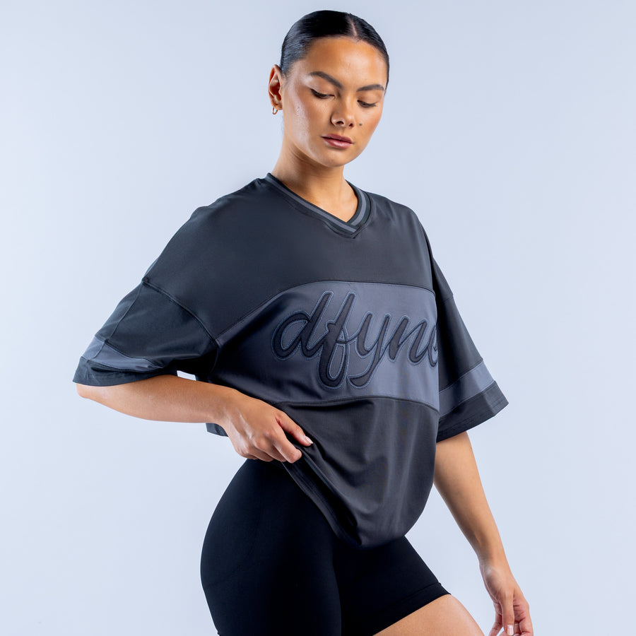 Dark short-sleeve top with cursive logo print across the chest