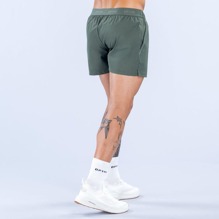 Dark green training shorts, back view with elastic waistband and roomy fit