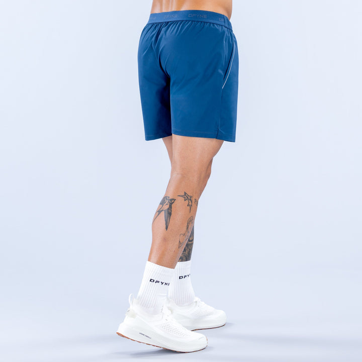 Men's blue training shorts, back view, elastic waistband, logo at hem, 6 in inseam