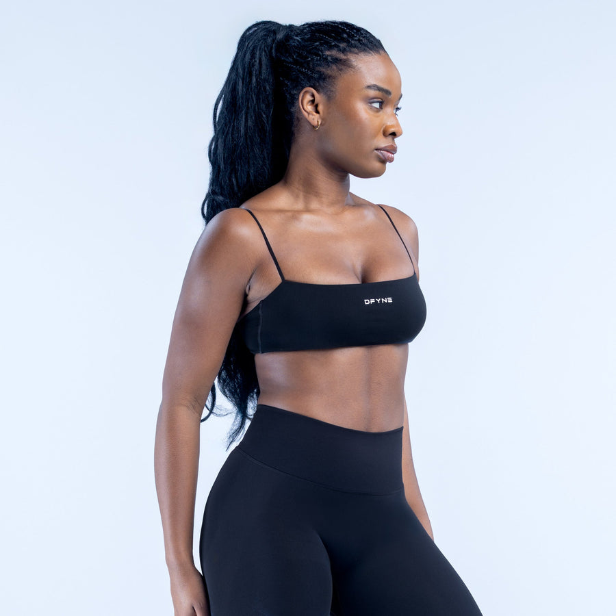 Black strappy bralette with thin spaghetti straps and DYNE logo on front