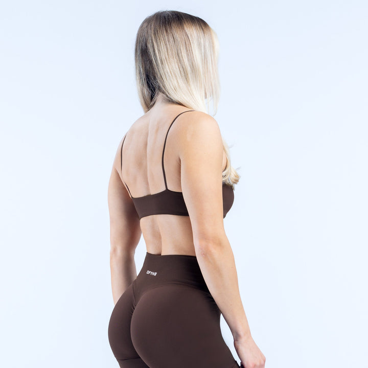 Women’s strappy sports bra back view, dark fabric and racerback straps