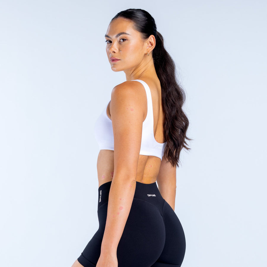 White scoop-back sports bra with visible back straps and wide neckline