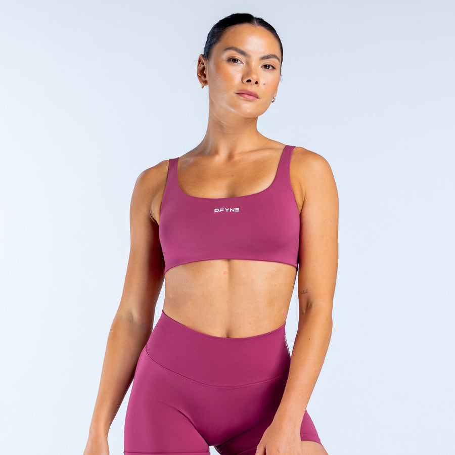 Magenta scoop back sports bra with wide scoop neckline and logo at center front