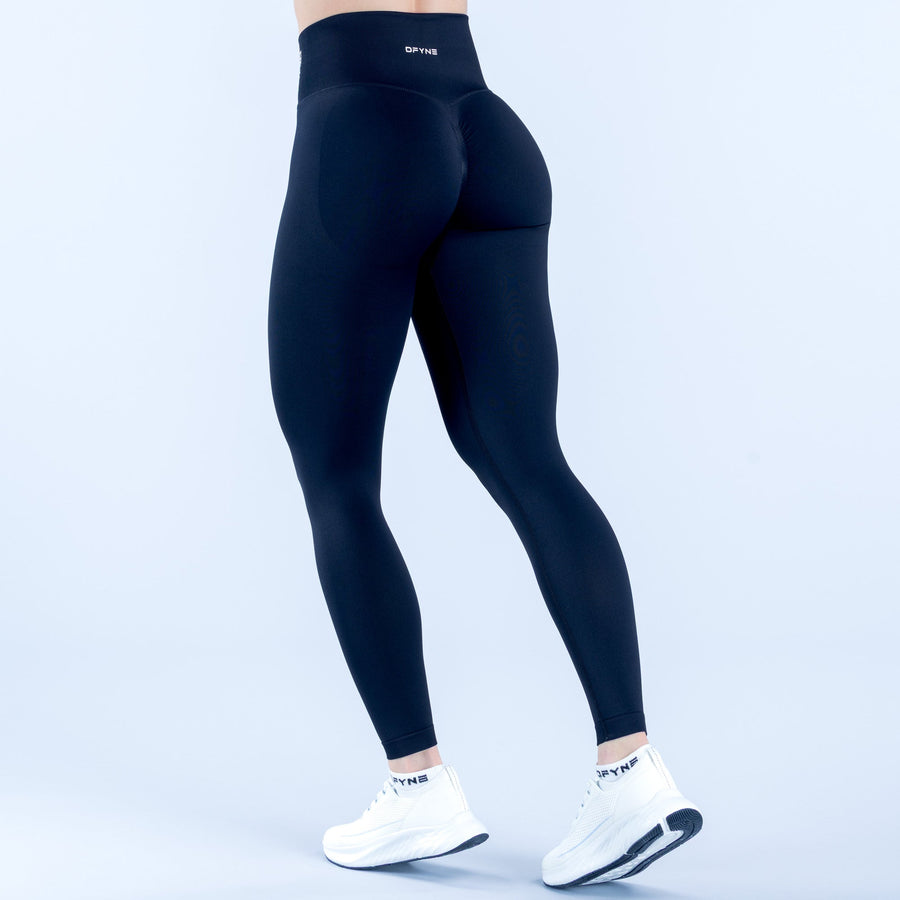 Black performance leggings, back view, logo waistband and contoured seams