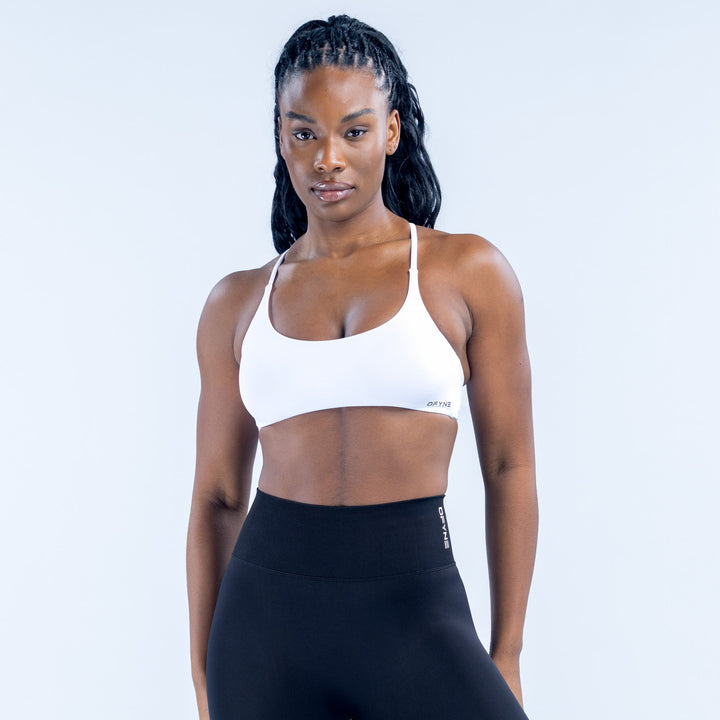 White twist-back sports bra with thin straps and scoop front