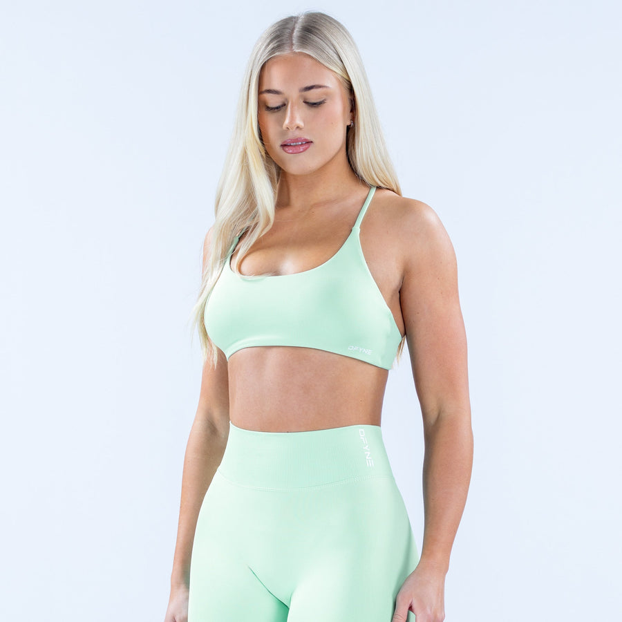Mint green twist-back sports bra with thin straps and smooth front fit