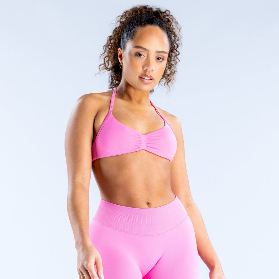 Pink strappy sports bra with ruched cups and thin adjustable straps