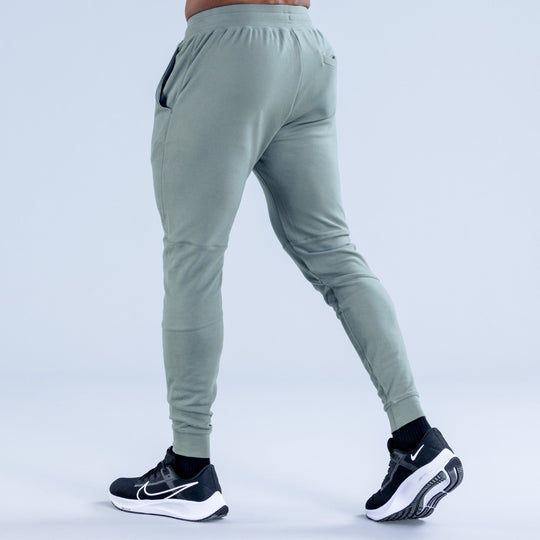 Sage green tapered jogger pants with back zip pocket and ankle cuff hems