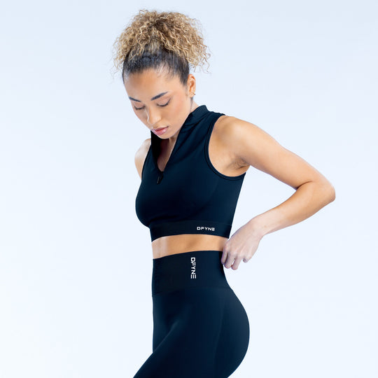 Black quarter-zip sleeveless athletic tank with cropped fit and chest logo