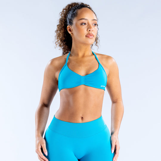 Turquoise strappy bra with ruched cups, thin adjustable straps, small logo