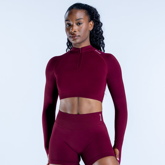 Burgundy long-sleeve zip-front crop top, high neckline, fitted athletic fabric