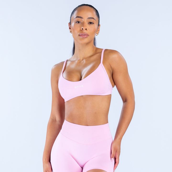 Pink scoop-neck sports bra with adjustable thin straps and racerback style