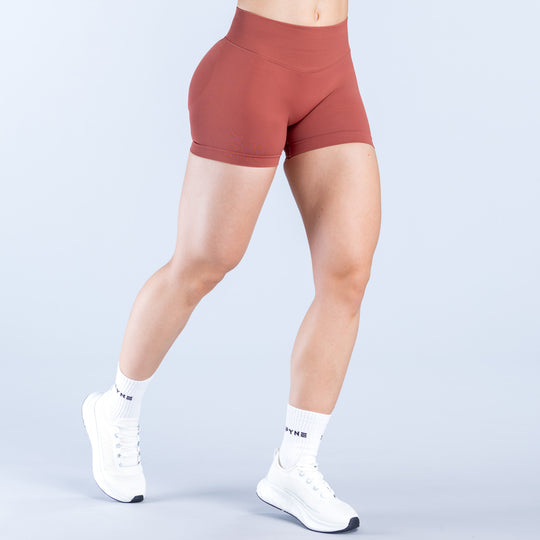 Rust red 4.5-inch impact shorts with fitted hips and high-rise waist