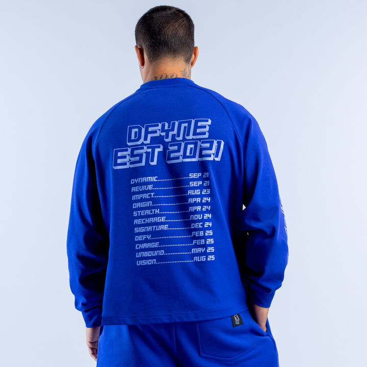 Blue long sleeve top with back white DEFY EST. 2021 print and date list