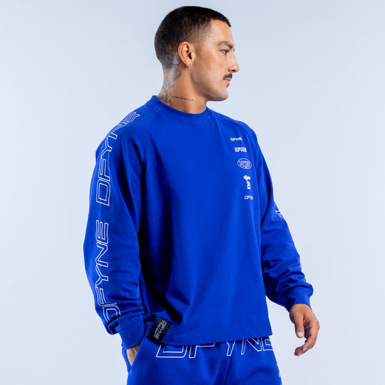 Blue long sleeve top with white logo patch on chest and graphic sleeve print