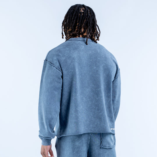 Washed blue crewneck sweatshirt, back view with ribbed cuffs and waistband