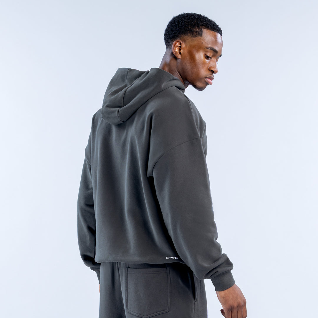 Back view of dark gray heavyweight zip hoodie with hood and small logo near the hem.