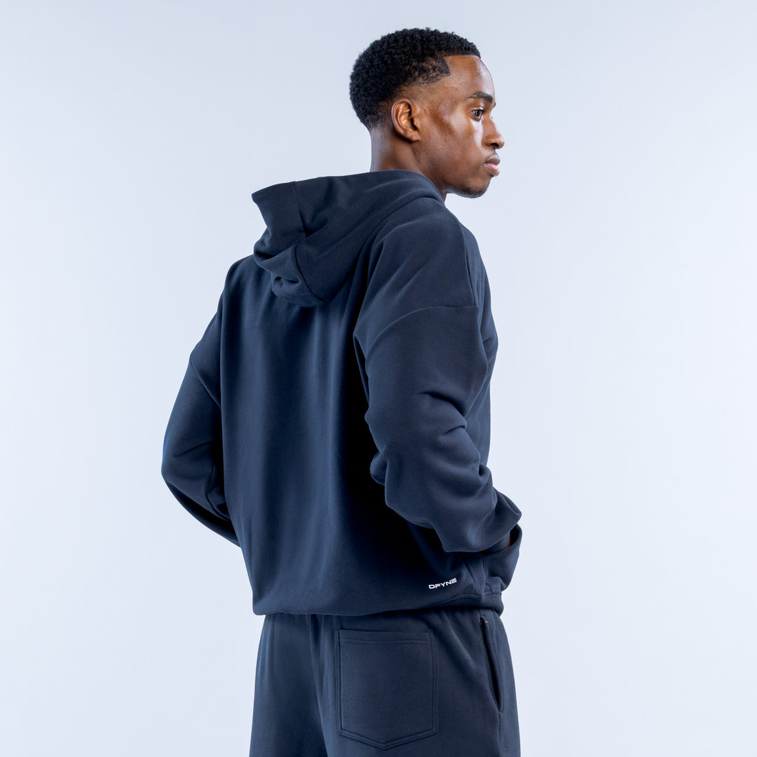 Navy zip hoodie shown from the back, with hood and small logo near the hem