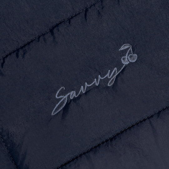 Embroidered script logo on dark quilted puffer bag panel
