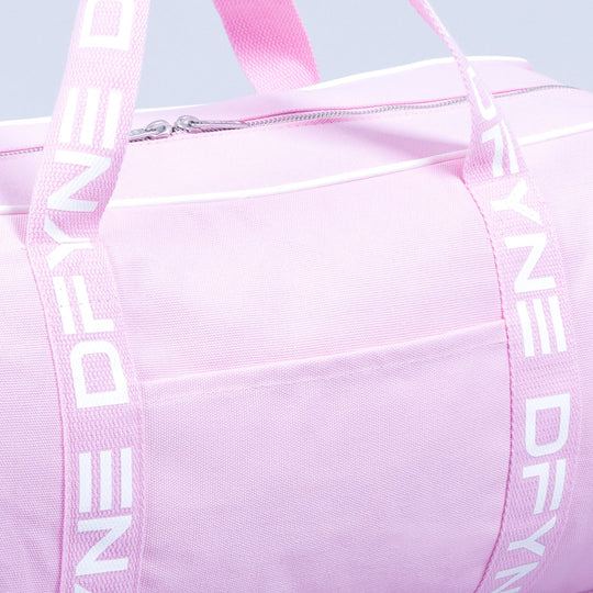 Light pink duffle bag close-up: zip pocket front and webbing shoulder straps.