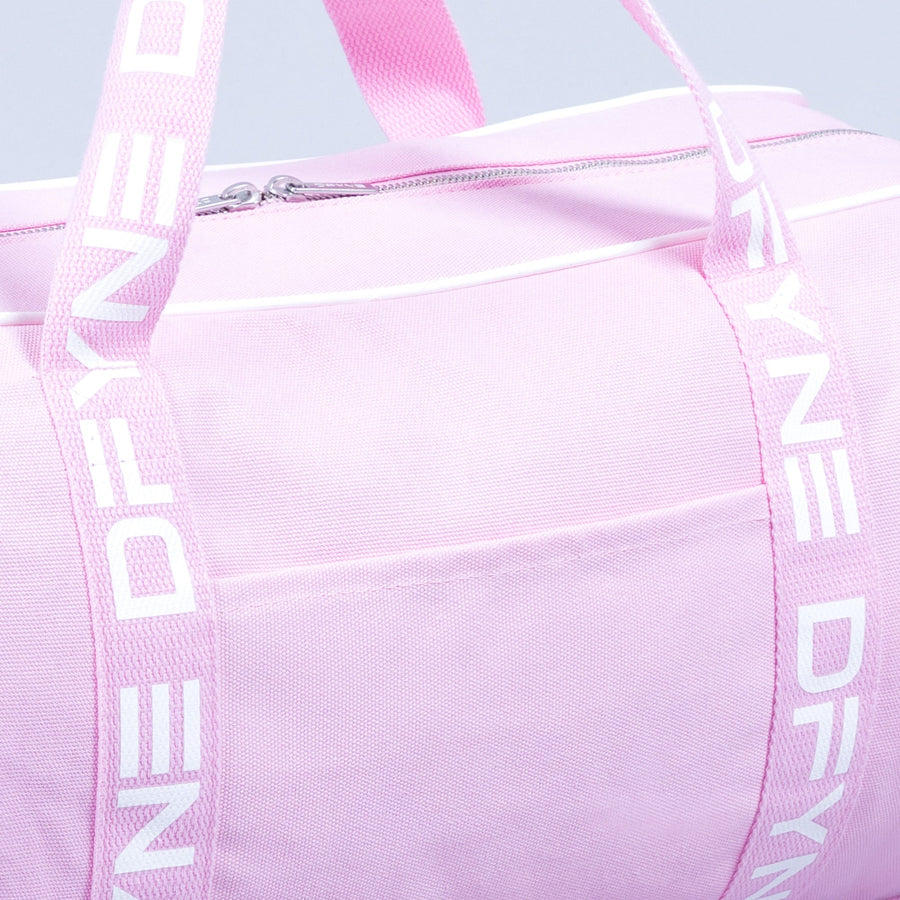 Light pink duffle bag close-up: zip pocket front and webbing shoulder straps.