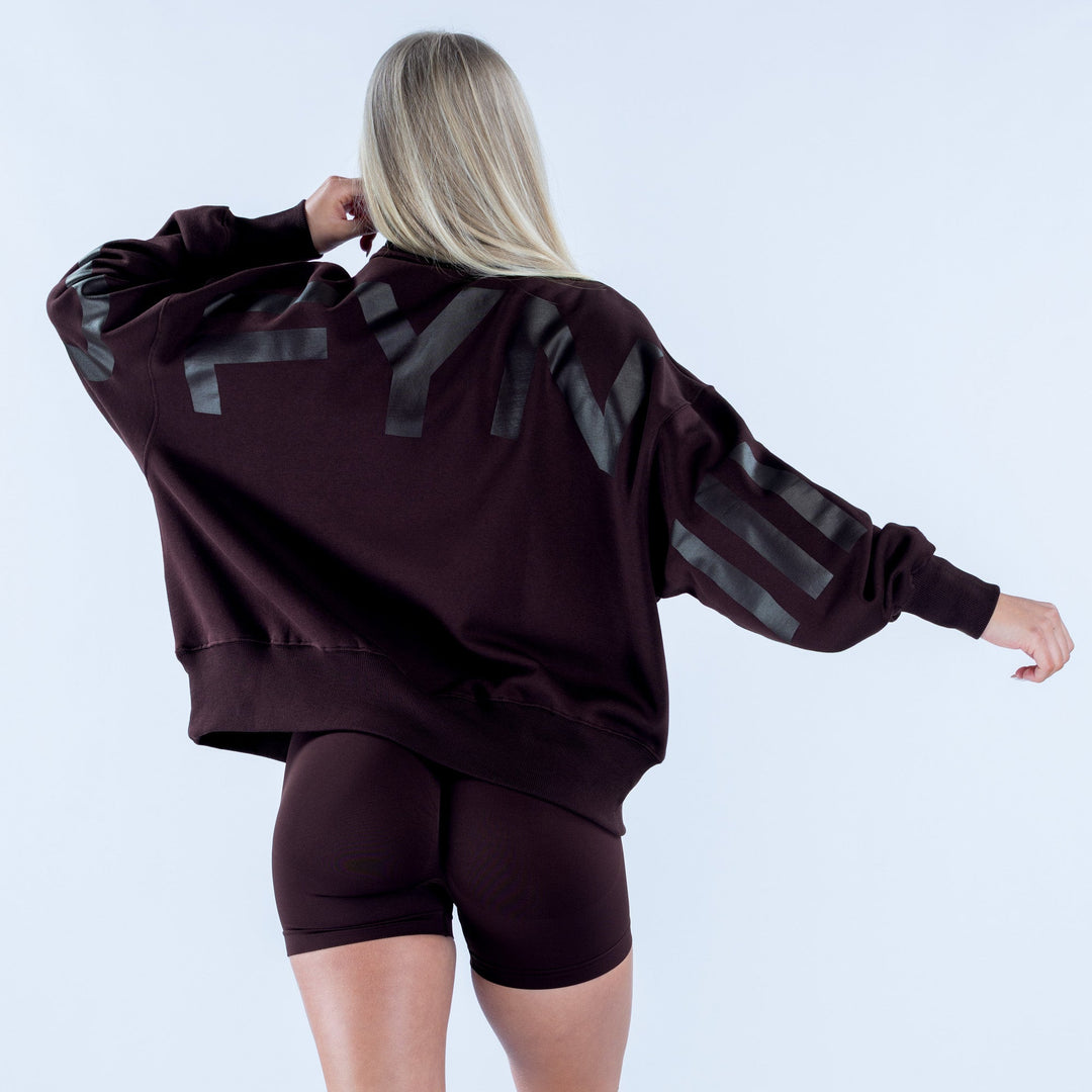 Back view dark plum quarter-zip sweatshirt with large gray patch graphic