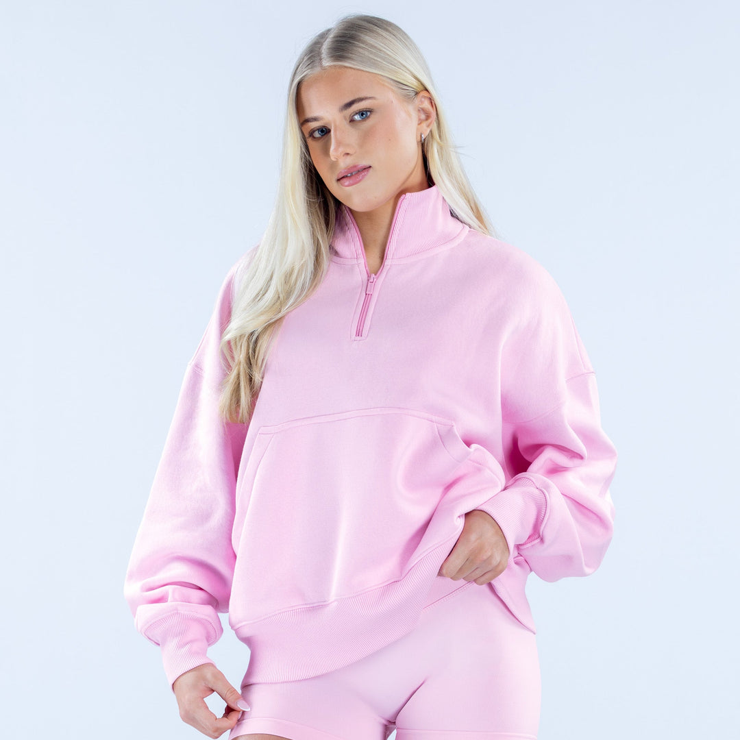 Pink quarter-zip sweatshirt with half-placket, kangaroo pocket, and long sleeves