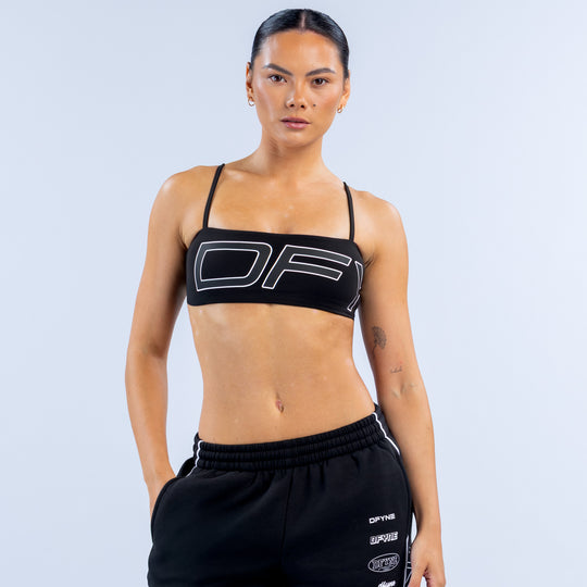 Girls' black sports bra with thin straps and bold white logo graphic