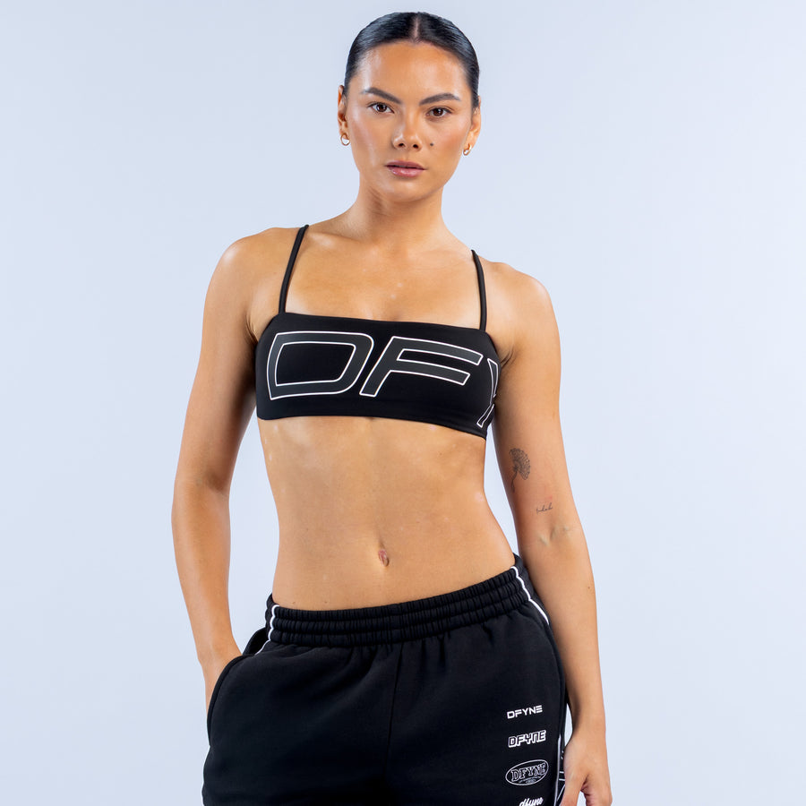 Girls' black sports bra with thin straps and bold white logo graphic